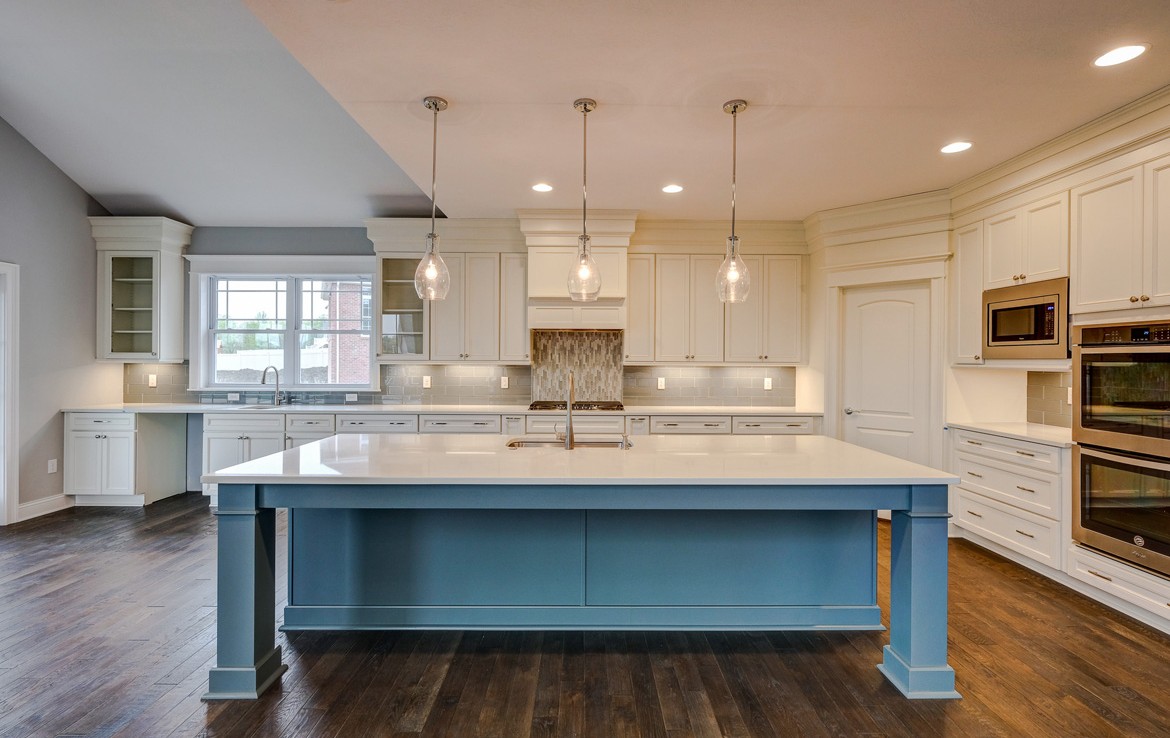 cambridge luxury home white kitchen cabinets, teal island, white countertop – Infinity Custom Homes