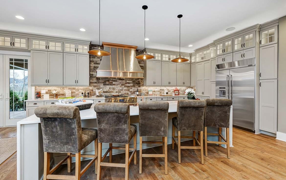 Austin Model Home at Forest Edge, Cranberry, PA, white and gray cabinets, stone backsplash, and copper details – Infinity Custom Homes