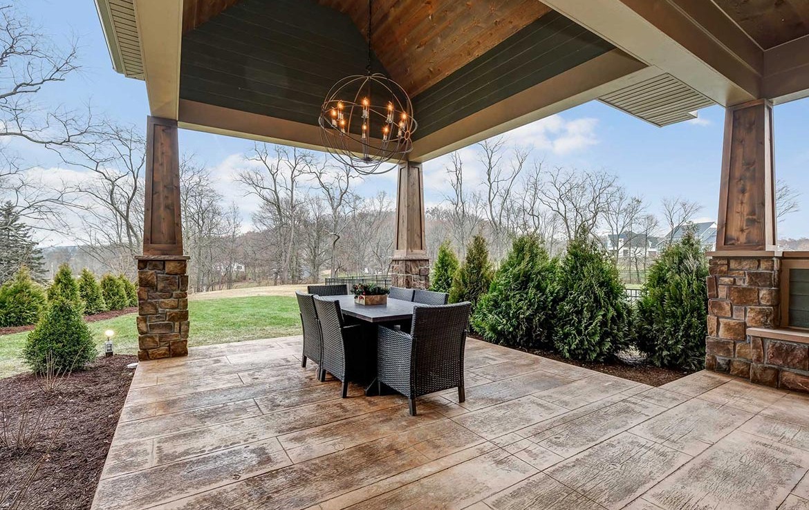 Austin Model Home at Forest Edge, Cranberry, PA, covered patio with tile and wooden columns – Infinity Custom Homes