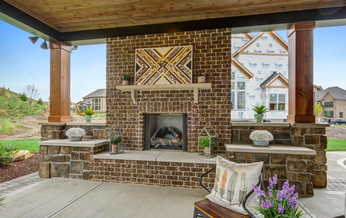 Nantucket Model Home, tudor style luxury home, exterior patio fireplace – Infinity Custom Homes