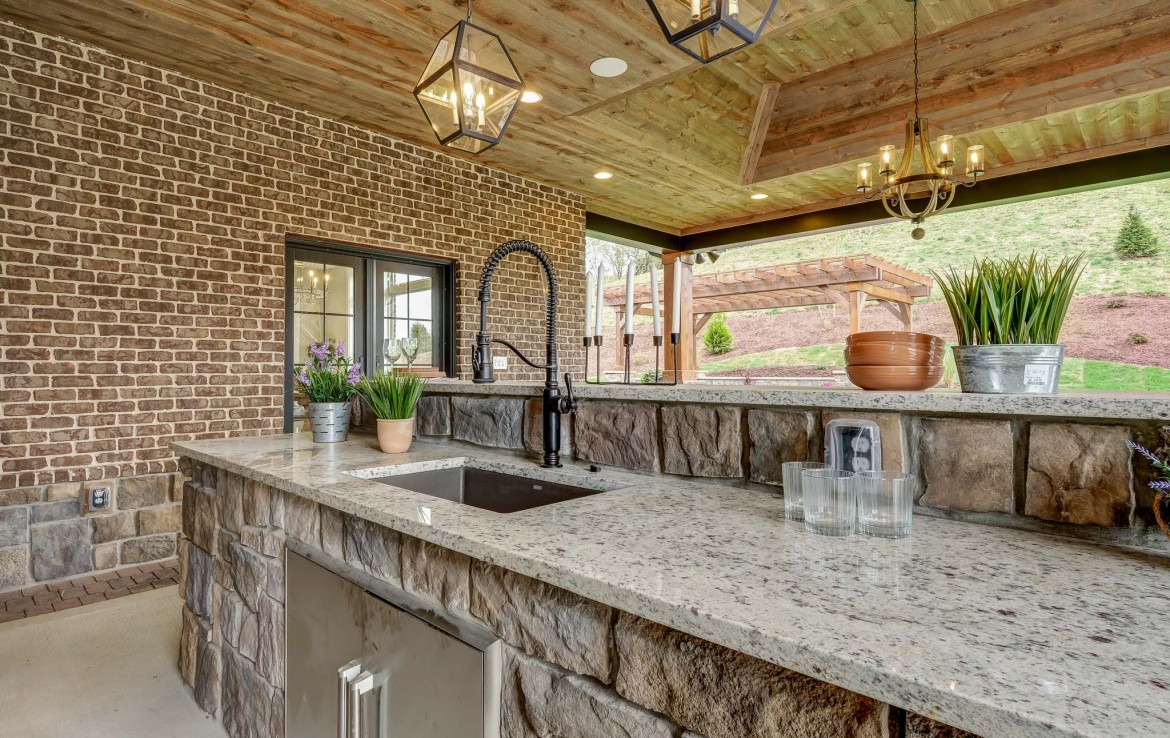 Nantucket Model Home, tudor style luxury home, exterior patio outdoor kitchen – Infinity Custom Homes